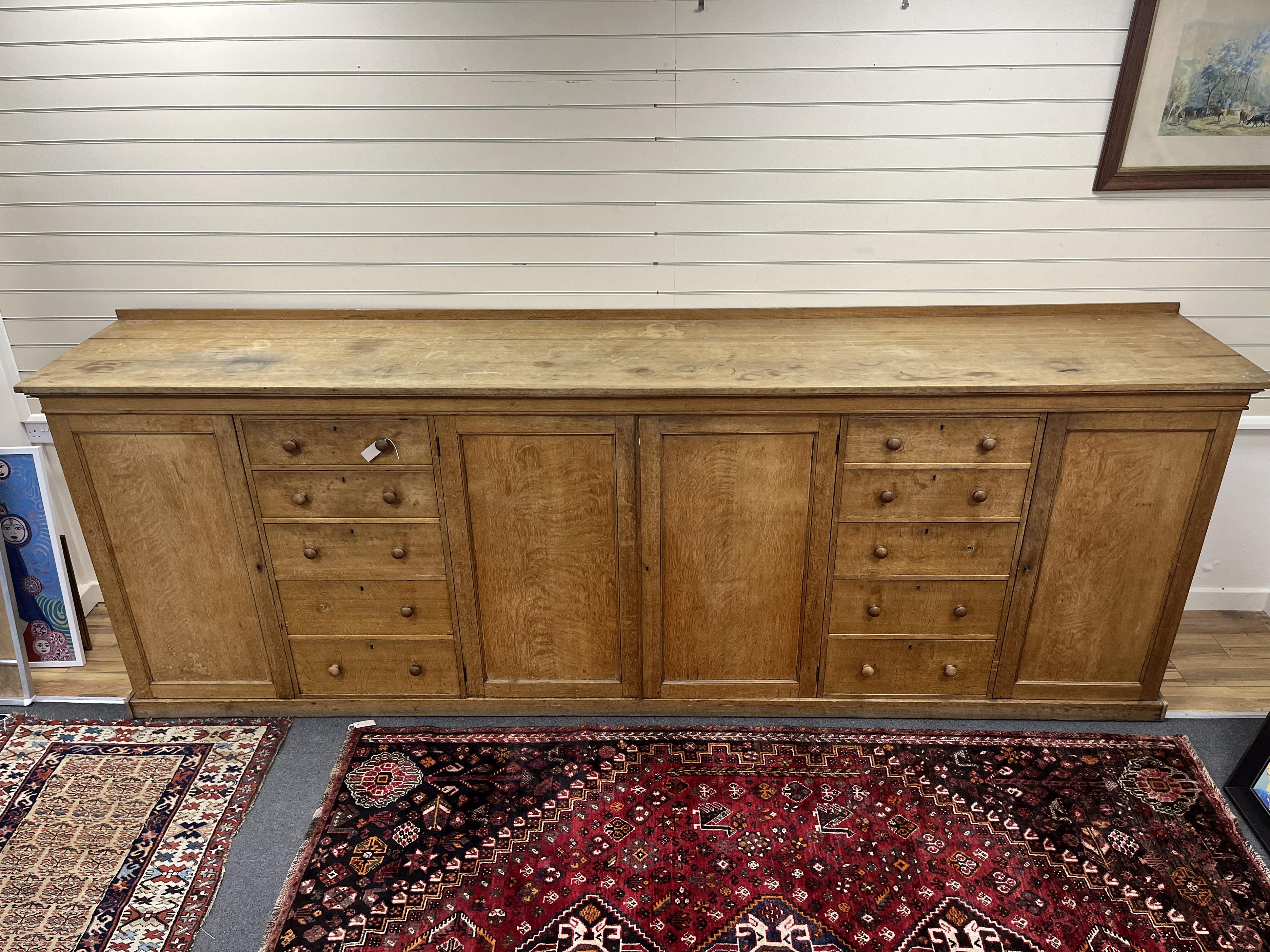 A late Victorian oak estate press cupboard, width 366cm, depth 64cm, height 130cm. Condition - fair